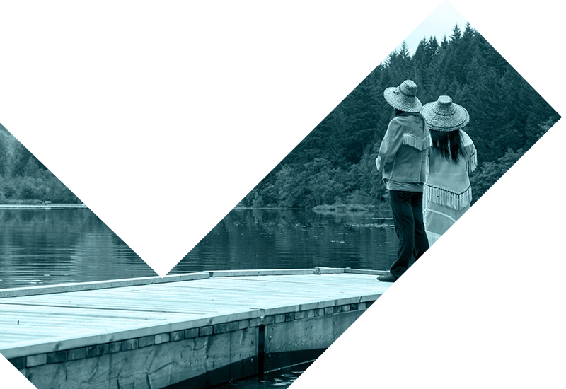 Indigenous people enjoying the view from a dock overlooking a lake